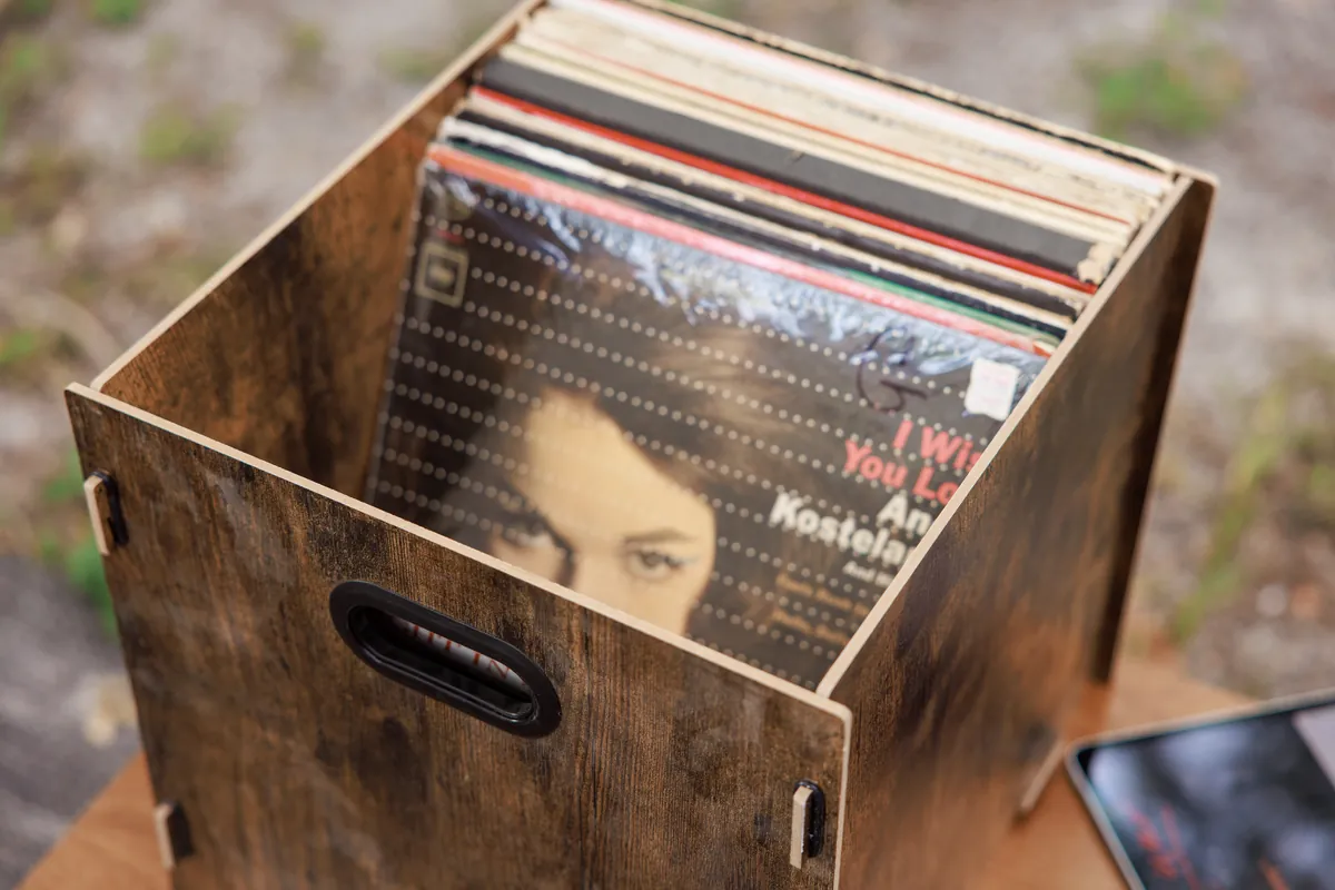 Wood record crate holding vinyl LPs at the listening station